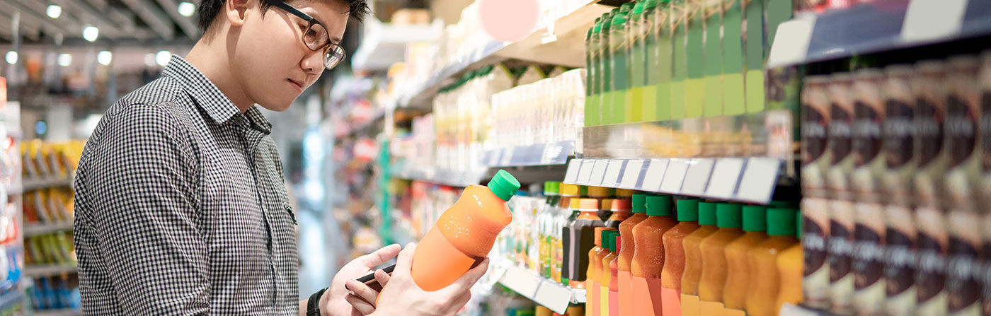 man grocery shopping in beverage aisle